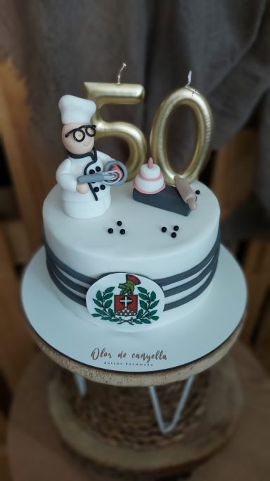 Tarta decorada con un chef de fondant y el número 50 en la parte superior.